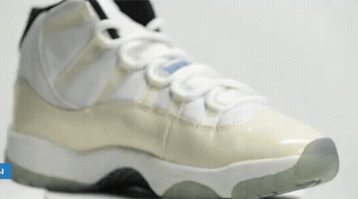 A Close Up Of A Pair Of White And Grey Sneakers On A White Surface . GIF
