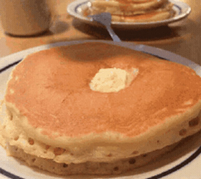 A Close Up Of A Pancake With Butter On Top On A Plate GIF