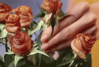 A Close Up Of A Person Arranging A Bouquet Of Roses Made Out Of Bacon GIF