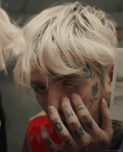 A Close Up Of A Person Covering Their Face With Their Hands With A Tattoo On Their Finger That Says ' A ' GIF