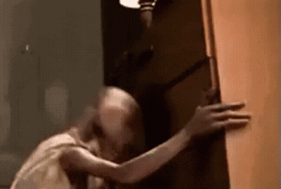 A Close Up Of A Person Holding A Door In A Room . GIF