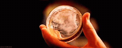 A Close Up Of A Person Holding A Glass Ball In Their Hand . GIF