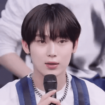 A Close Up Of A Person Holding A Microphone In Their Hand . GIF