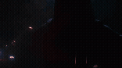 A Close Up Of A Person Holding A Red Lightsaber In A Dark Room . GIF