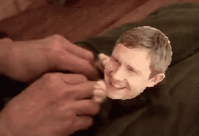 A Close Up Of A Person Holding A Small Head Of A Man GIF