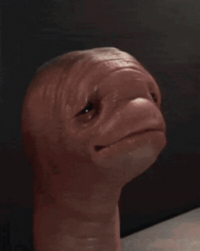 A Close Up Of A Person Holding A Statue Of An Alien . GIF