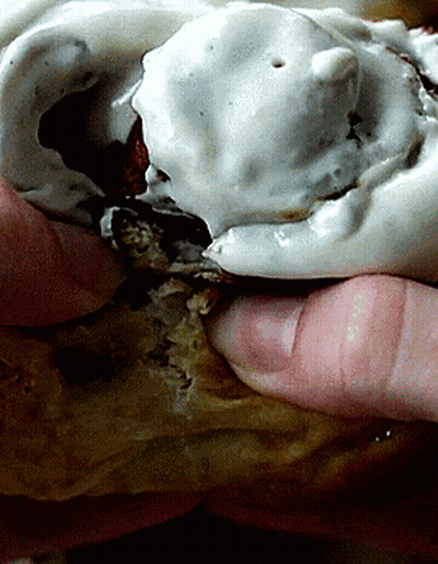 A Close Up Of A Person Holding A Statue With White Frosting On It GIF