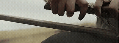 A Close Up Of A Person Holding A Sword . GIF