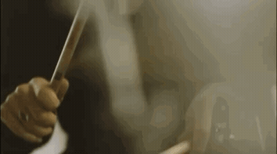 A Close Up Of A Person Holding A Trumpet In A Dark Room . GIF
