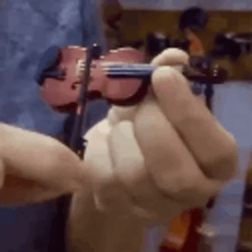 A Close Up Of A Person Holding A Violin In Their Hand . GIF