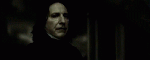 A Close Up Of A Person Holding A Wand In A Dark Room In A Movie . GIF