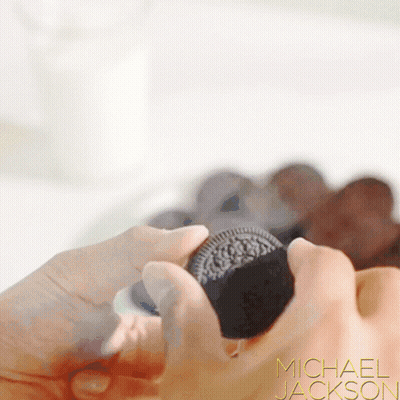 A Close Up Of A Person Holding An Oreo Cookie With Michael Jackson Written On The Bottom Right GIF