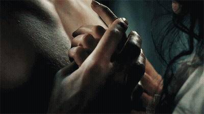 A Close Up Of A Person Holding Another Person 'S Hand In A Dark Room GIF