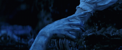 A Close Up Of A Person Holding Another Person 'S Hand In The Dark GIF