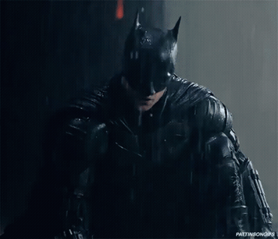 A Close Up Of A Person In A Batman Costume In The Rain GIF