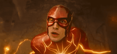 A Close Up Of A Person In A Flash Costume With A Lightning Bolt Behind Them . GIF