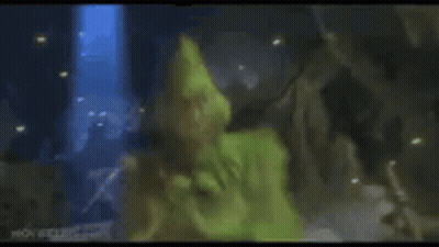 A Close Up Of A Person In A Green Costume Laying On The Ground . GIF