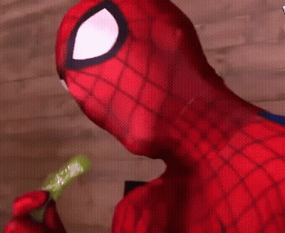 A Close Up Of A Person In A Spiderman Costume Eating A Pickle . GIF
