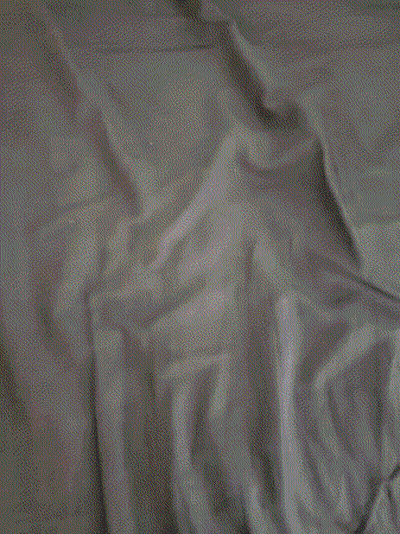 A Close Up Of A Person Laying On A Bed Covered In Sheets GIF