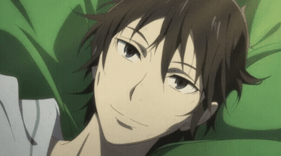 A Close Up Of A Person Laying On A Bed With A Green Blanket . GIF