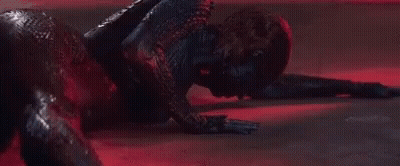 A Close Up Of A Person Laying On The Floor In A Dark Room With A Red Light Behind Them . GIF