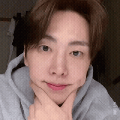 A Close Up Of A Person Making A Face With Their Hands On Their Chin . GIF