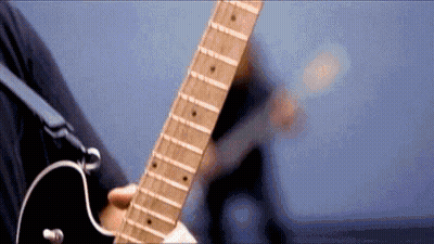 A Close Up Of A Person Playing A Guitar With A Blue Background . GIF