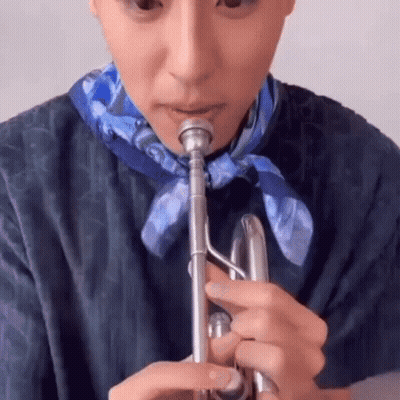 A Close Up Of A Person Playing A Trumpet . GIF
