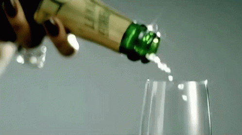 A Close Up Of A Person Pouring Champagne Into A Glass . GIF