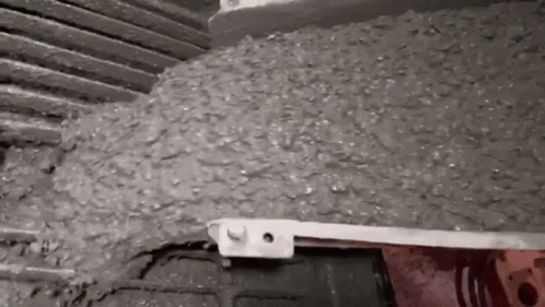 A Close Up Of A Person Pouring Concrete Into A Container . GIF