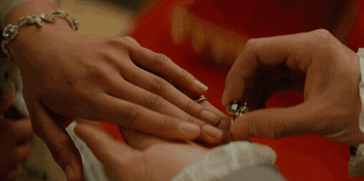 A Close Up Of A Person Putting A Ring On Another Person 'S Finger GIF