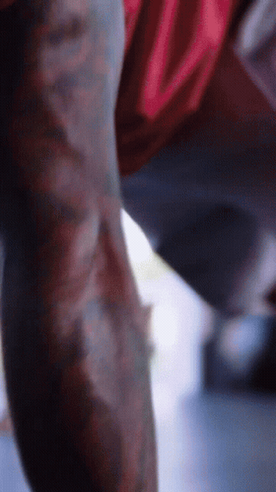 A Close Up Of A Person 'S Arm With A Red Shirt That Has The Letter U On It GIF