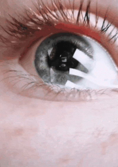 A Close Up Of A Person 'S Blue Eye With Long Eyelashes GIF