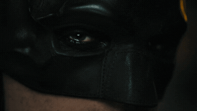 A Close Up Of A Person 'S Eye Wearing A Batman Mask GIF