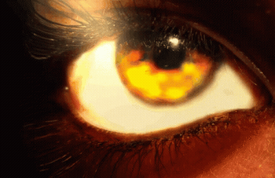 A Close Up Of A Person 'S Eye With A Yellow Glow In It GIF