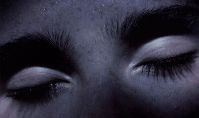 A Close Up Of A Person 'S Eyes With A Purple Background GIF