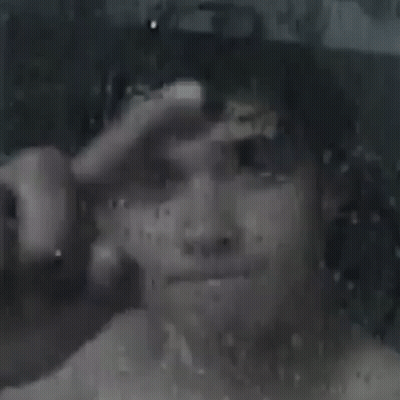 A Close Up Of A Person 'S Face Behind A Window With Rain Drops . GIF