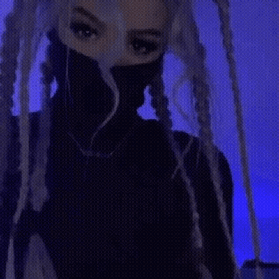 A Close Up Of A Person 'S Face In A Dark Room With A Blue Light In The Background . GIF