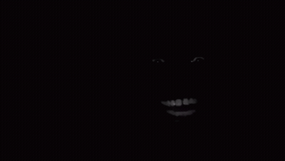 A Close Up Of A Person 'S Face In The Dark With A Smile On It . GIF