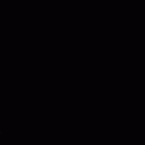 A Close Up Of A Person 'S Face In The Dark With Their Fingers Visible . GIF