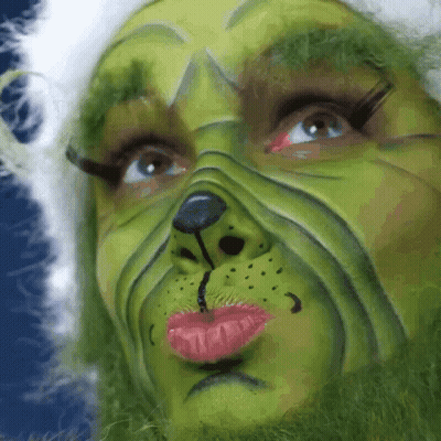A Close Up Of A Person 'S Face Painted To Look Like A Grinch GIF