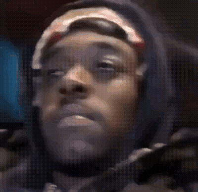 A Close Up Of A Person 'S Face Wearing A Hoodie And A Headband . GIF