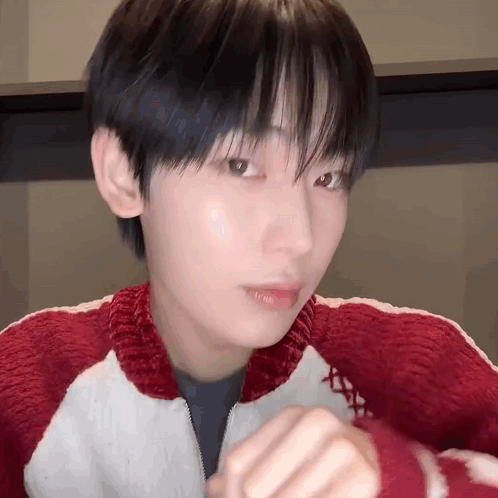 A Close Up Of A Person 'S Face Wearing A Red And White Sweater . GIF