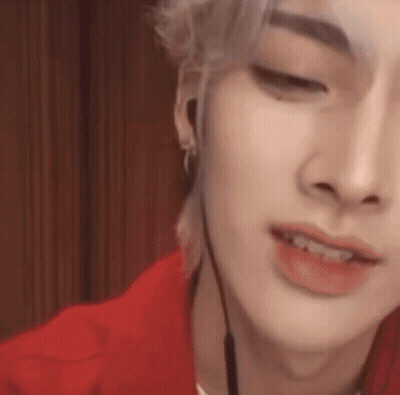 A Close Up Of A Person 'S Face Wearing Headphones And A Red Shirt . GIF
