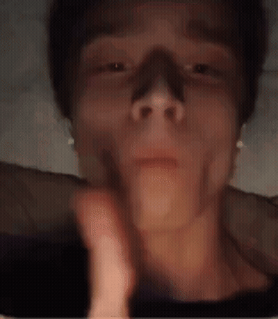 A Close Up Of A Person 'S Face Wearing Headphones And Smoking A Cigarette . GIF