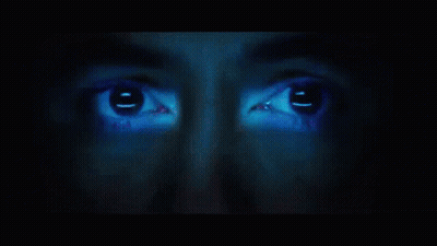 A Close Up Of A Person 'S Face With A Blue Light Shining On It GIF