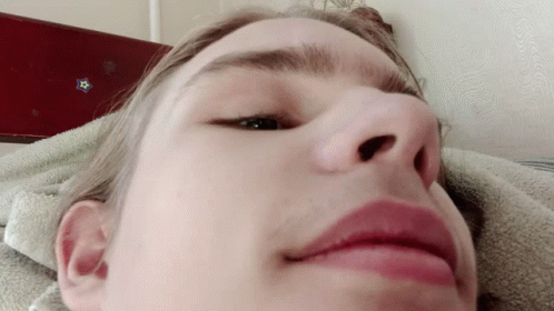 A Close Up Of A Person 'S Face With A Blue Star On The Wall Behind Them GIF