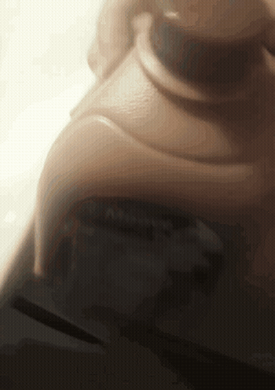 A Close Up Of A Person 'S Face With A Blurred Background And A Button That Says ' A ' On It GIF