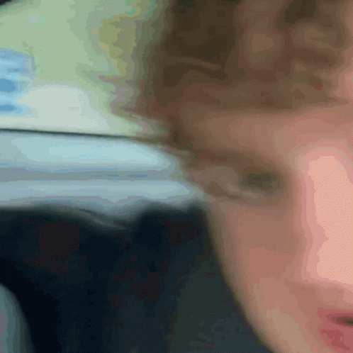 A Close Up Of A Person 'S Face With A Blurry Background And A Blue Item In The Background GIF