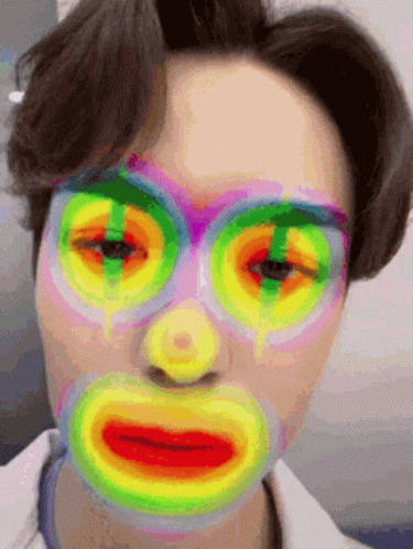 A Close Up Of A Person 'S Face With A Colorful Mask On . GIF